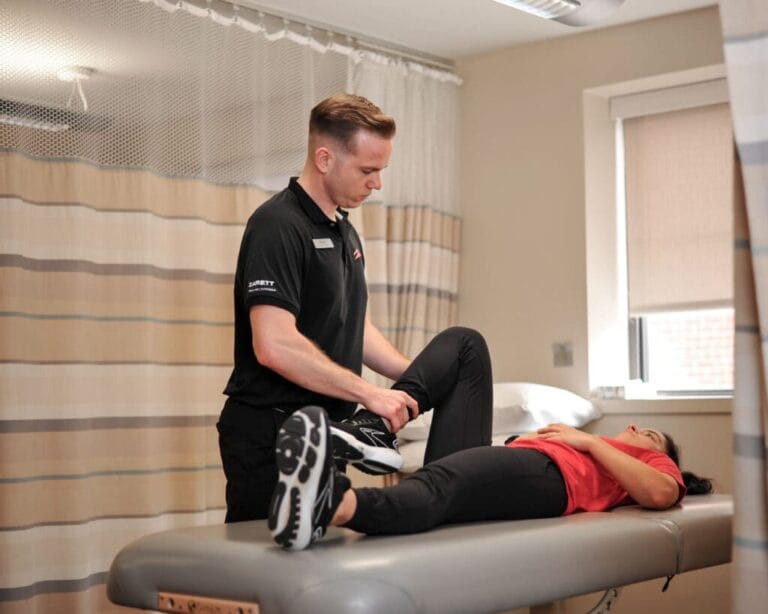 Physical therapist assisting with flexibility stretch